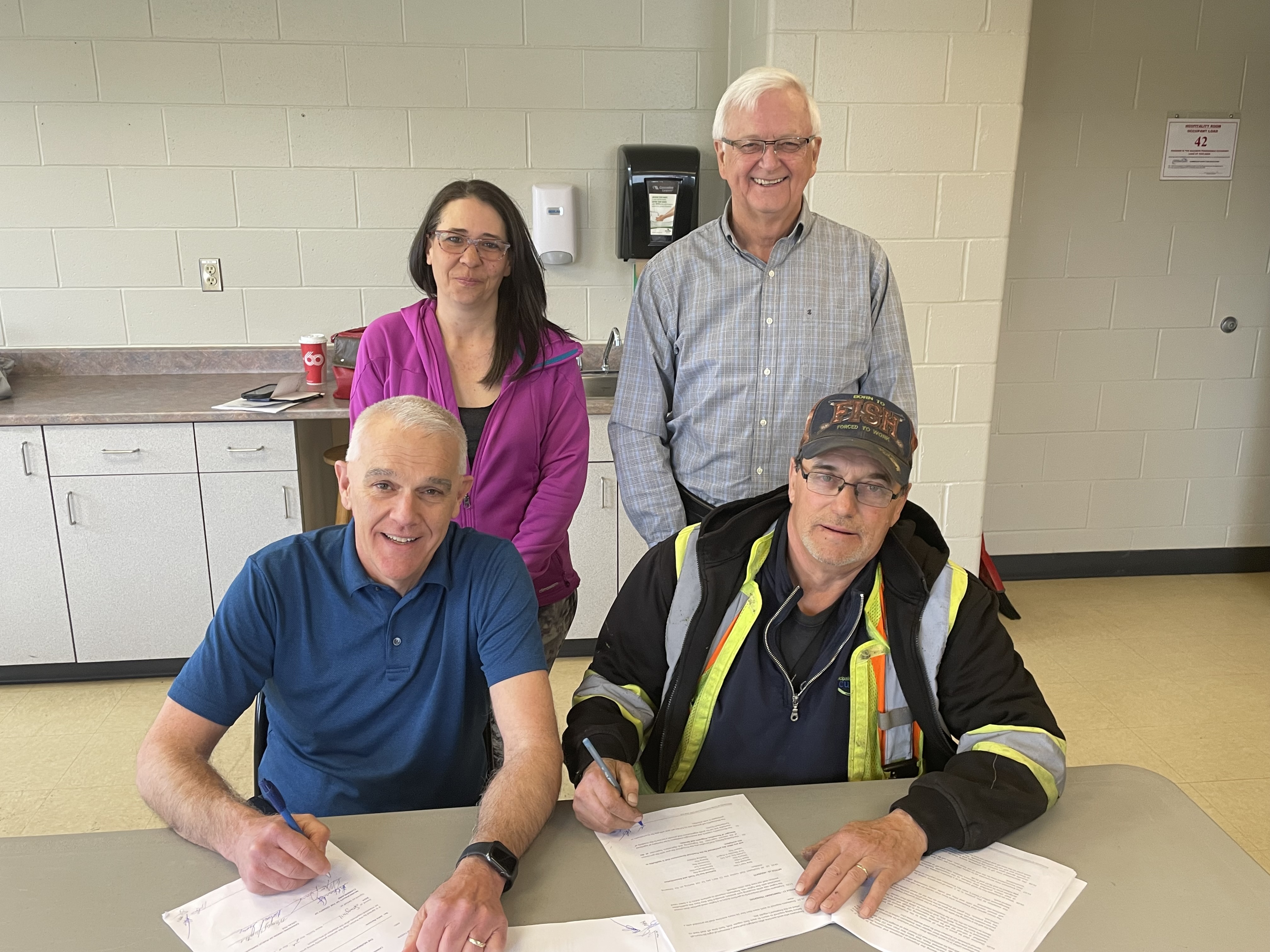 Municipality of Cumberland CAO Greg Herrett (seated left) and CUPE Local 919 President Mike Gerrior (seated right) sign a new four-year collective agreement between the union and the municipality while union vice-president Mandy Hunter and Mayor Murray Scott look on. Darrell Cole – Municipality of Cumberland photo