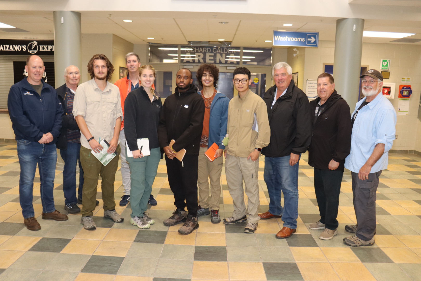 A group of people stand in the entryway of a building.