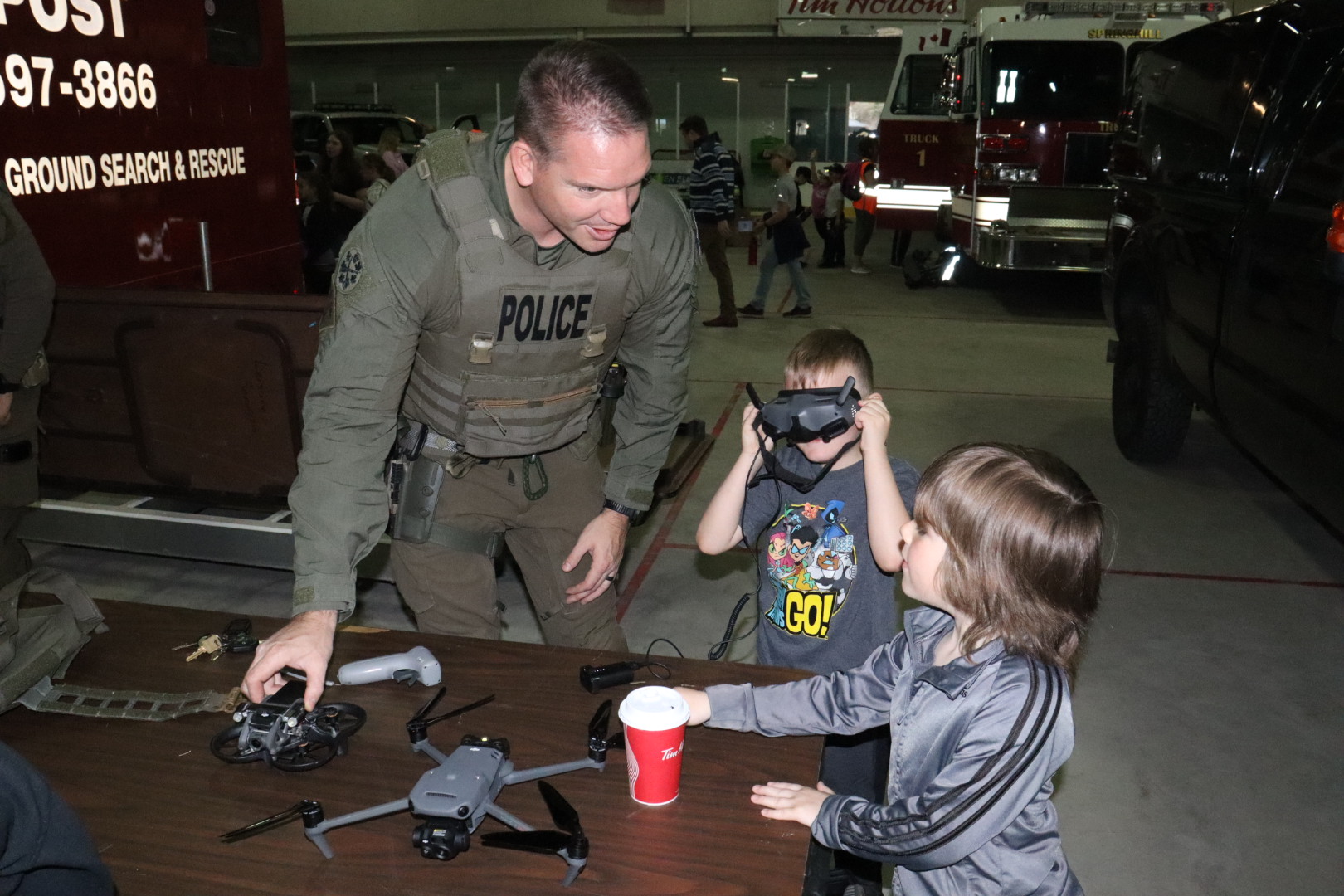 A police officer demonstrates a virtual- reality device to a group of children.