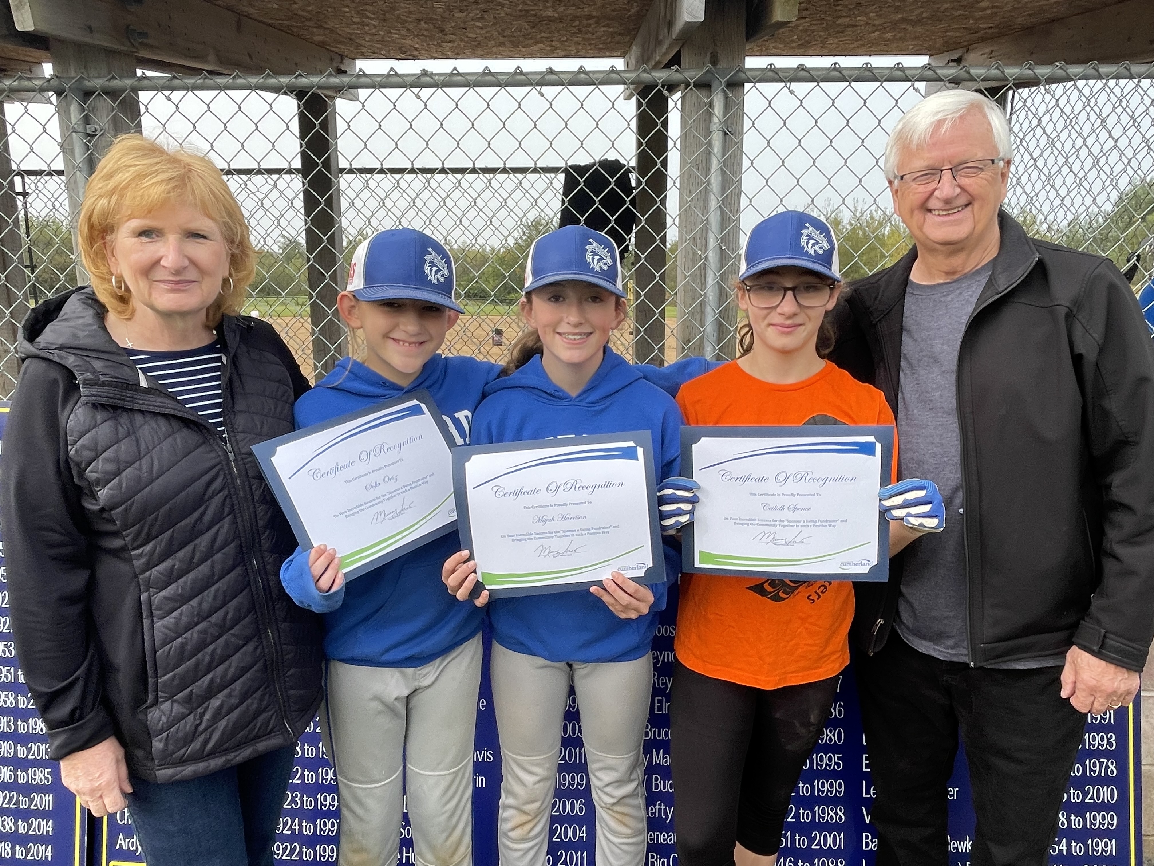 Cumberland municipal councillor Angel McCormick (left) and Mayor Murray Scott present certificates of appreciation to Springhill baseball players (from left) Sophia Ortiz, Miyah Harrison and Ceilidh Spence for their swing-a-thon fundraiser that repaired damage done by vandals at the Springhill Lions Park baseball diamond. Darrell Cole – Municipality of Cumberland photo